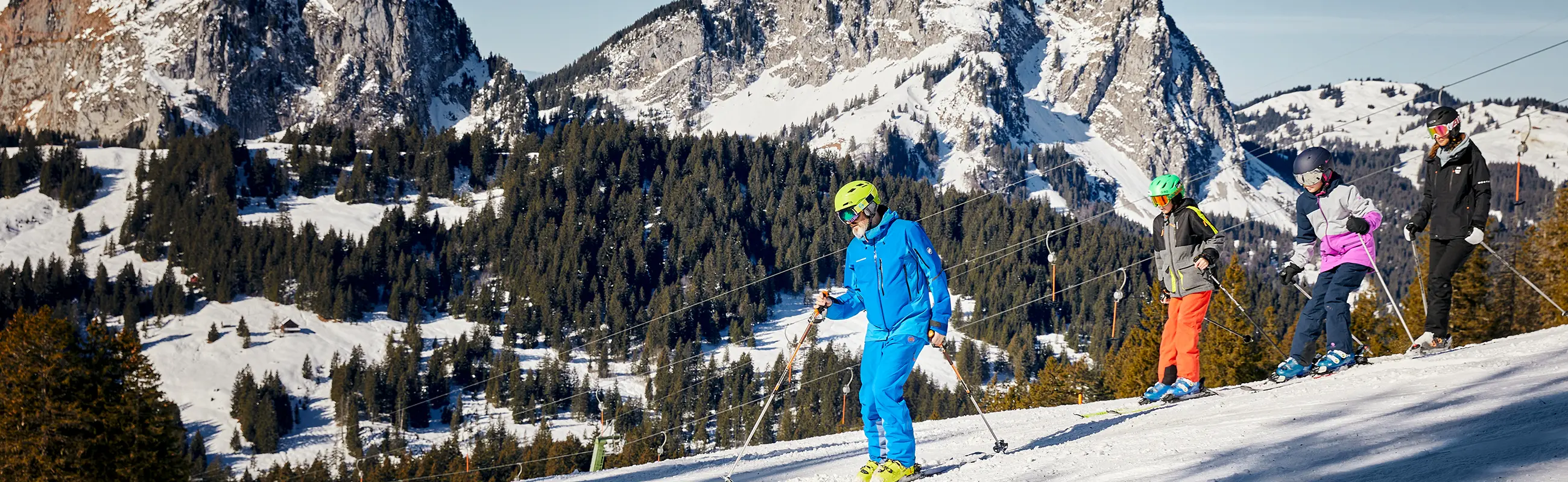 Skifahrer auf der Piste mit Mythen im Hintergrund