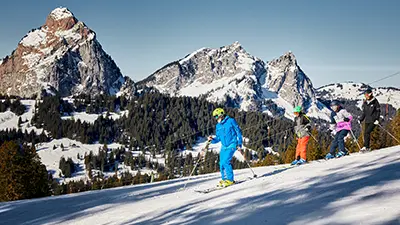 Skifahrer auf der Piste mit Mythen im Hintergrund